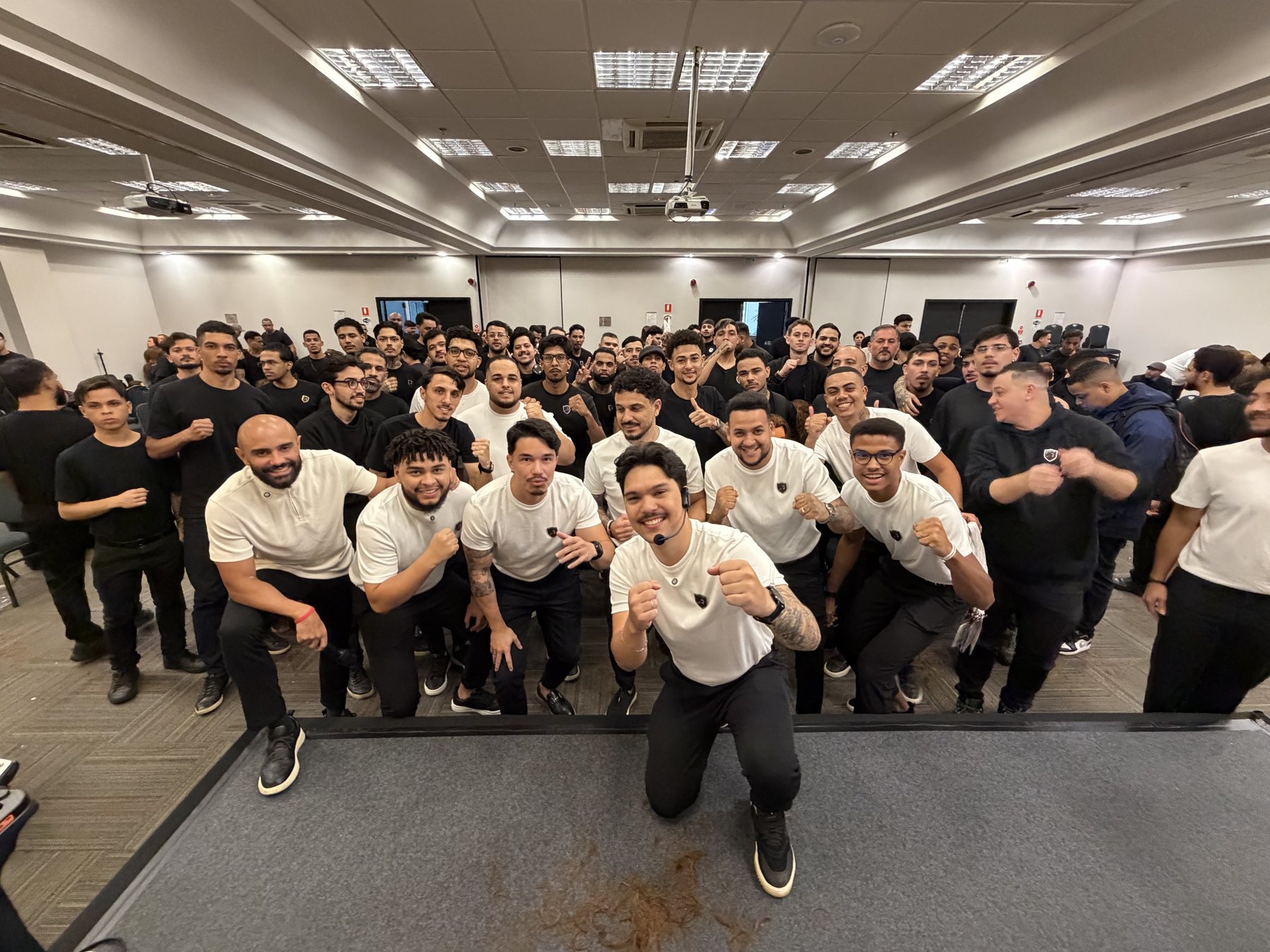 Treinamento da Rede Trezentos: time técnico de branco à frente e dezenas de barbeiros das unidades atrás