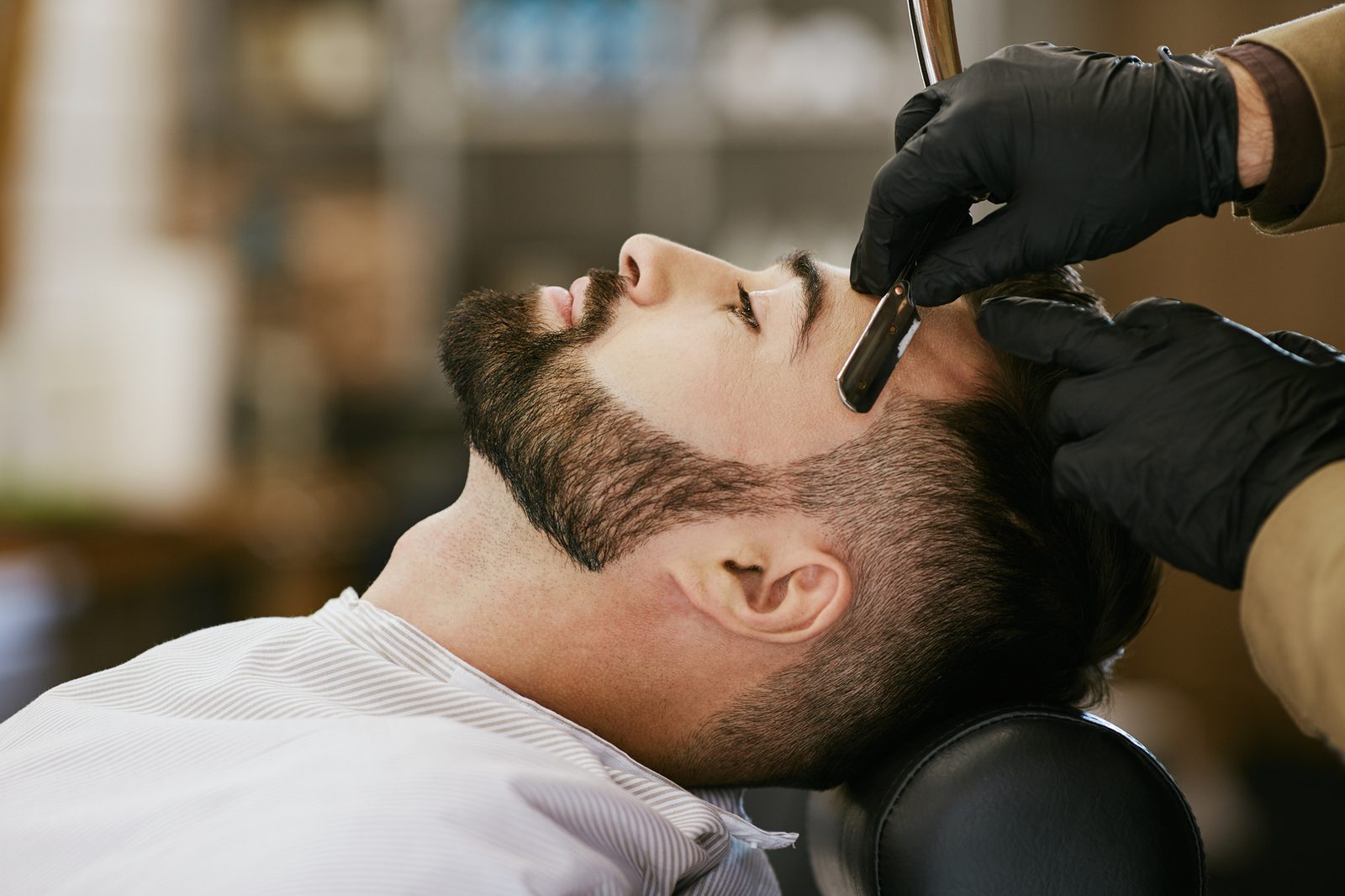 Barba sendo finalizada com navalha e toalha
